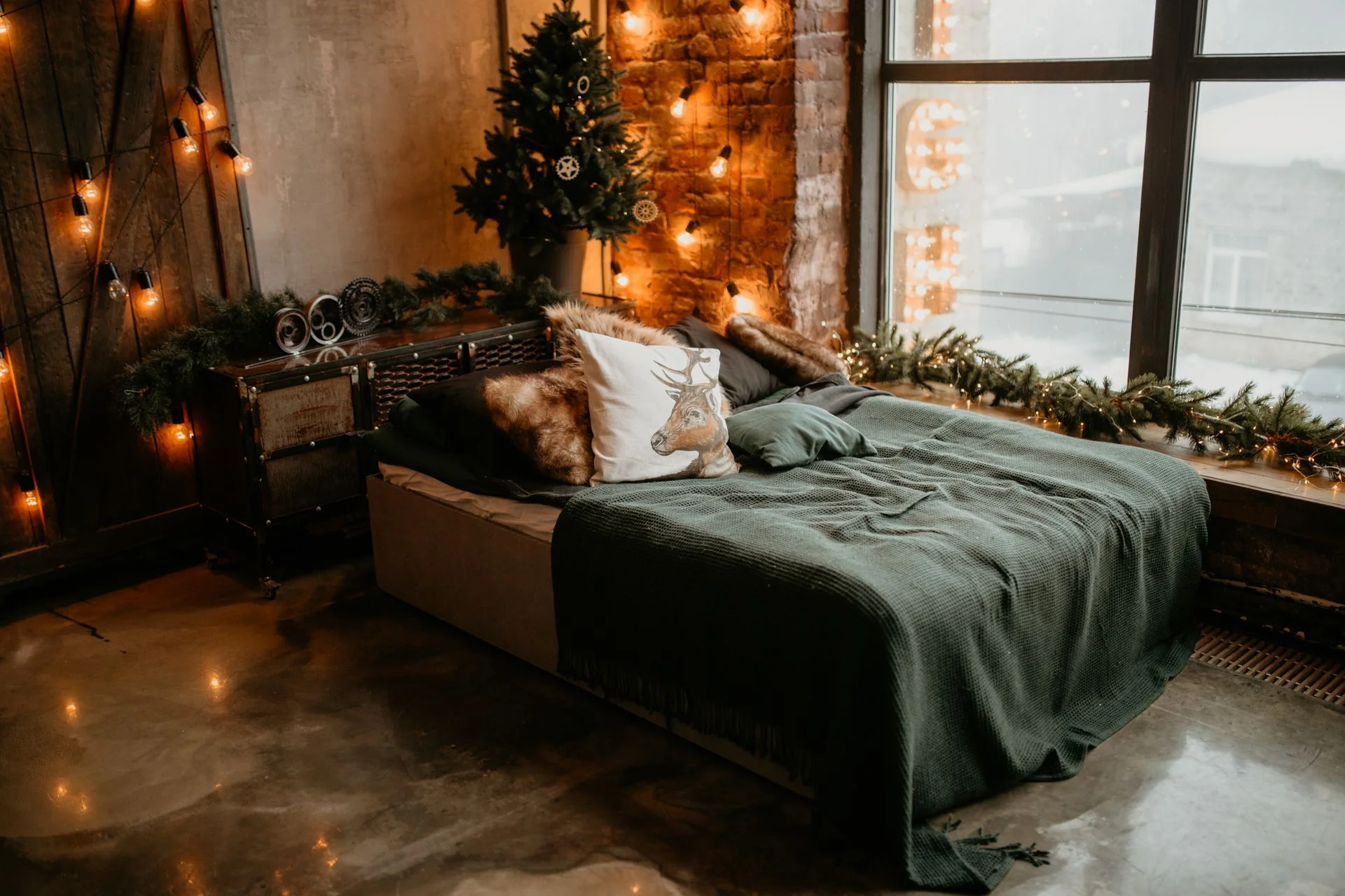 A warm decorated bedroom with a christmas tree and cozy bedding